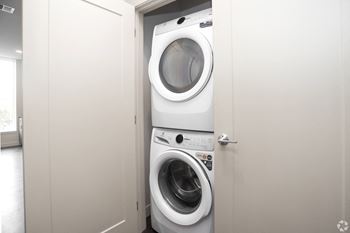 a small white washer and dryer in a laundry room
